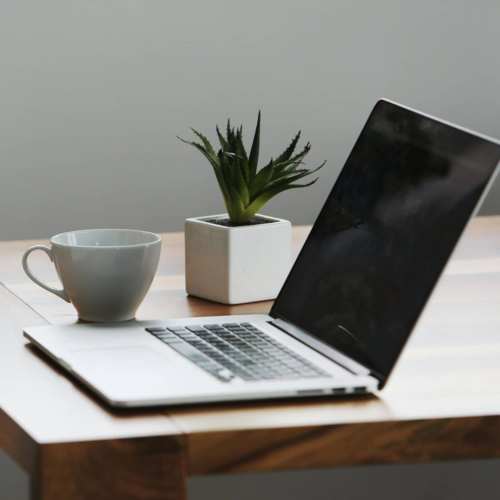 Laptop und Tasse auf einem Schreibtisch
